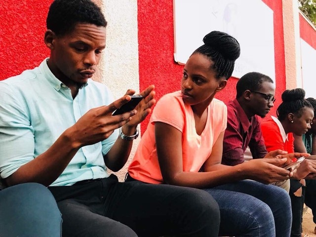 Galaxy FM Team: Producer Timo, Evening Rush Presenter Prim, Social Media Manager Bash and Evening Rush Presenter Mary Luswata use their phones to engage social media on awards launch night