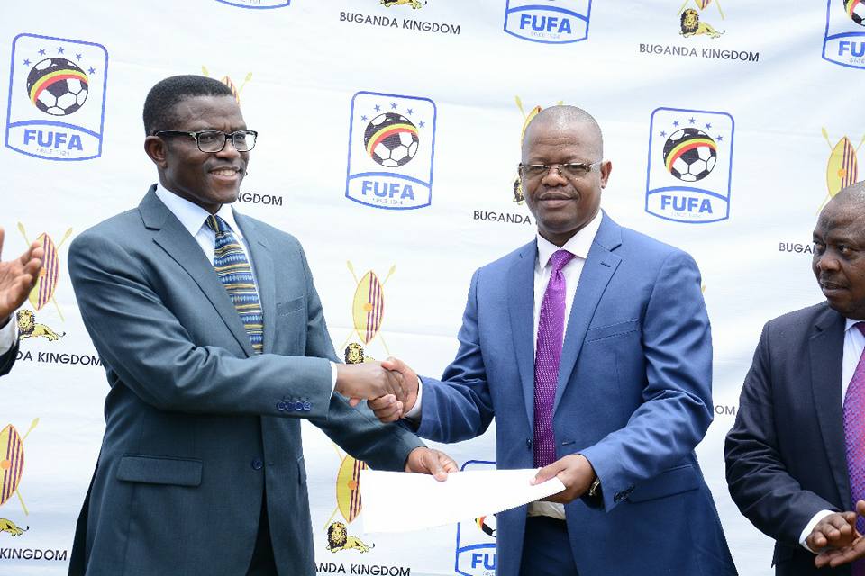 Buganda Prime minister, Mayiga (L) handing a land title to FUFA president, Magogo